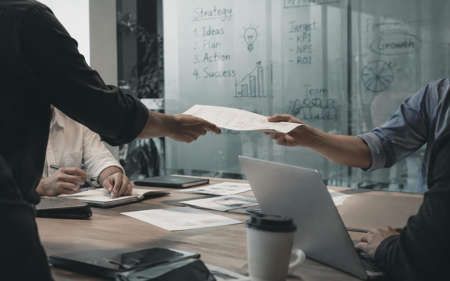 Placeholder: a team reviewing documents in a modern meeting room